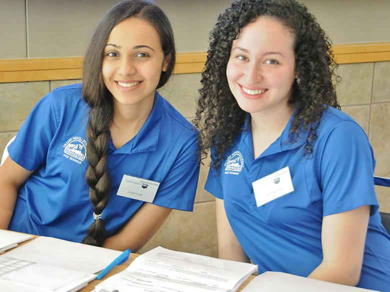 students posing and smiling together in blue penn state shirts